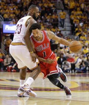 Chicago Bulls guard Derrick Rose (1) drives around Cleveland Cavaliers forward LeBron James (23) during the second half of Game 1 of their playoff series Monday in Cleveland. Photo by AP