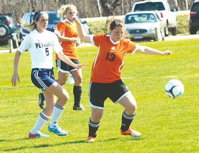 Cheboygan sophomore midfielder Olivia Arnold (right) chases for the ball with Petoskey's Laci Muszynski during a game on Monday.