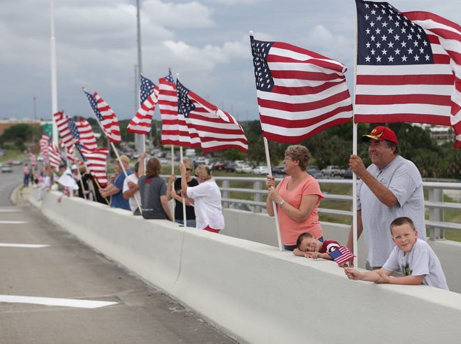 Supporters line the Hathaway Bridge during the Warrior Beach Retreat Parade. The University of Florida president and a fraternity have issued apologies for members' disrespect of veterans during the celebration.