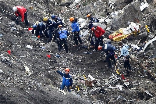 In this March 26, 2015 file photo, rescue workers work on debris of the Germanwings jet at the crash site near Seyne-les-Alpes, France. The co-pilot of Germanwings Flight 4525 tried a controlled descent on the previous flight that morning to Barcelona before the plane crashed into a mountainside in March on its way back to Germany, French air accident investigators said in a new report released Wednesday May, 6, 2015. (AP Photo/Laurent Cipriani, File)