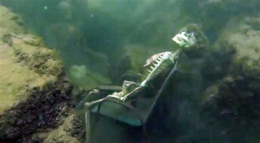 In this frame from video provided by the La Paz Sheriffs' Office, fake skeletons are strategically placed to appear as if they were sitting together with their lawn chairs bound to large rocks in the Colorado River near the Arizona and California border. A man snorkeling came across the two fake skeletons sitting in lawn chairs about 40 feet underwater and reported the skeletons to the La Paz County Sheriff's Office on Monday, May 4, 2015, launching a hunt for what authorities believed could be real bodies. It turned out the skeletons were fake. (AP Photo/La Paz Sheriff's Office)