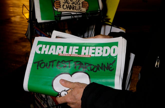 A seller of newspapers stocks several Charlie Hebdo newspapers at a newsstand in Nice, France, in January.