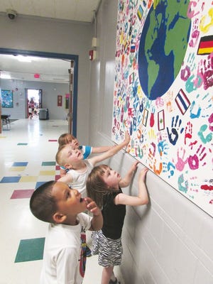 Lewis Beckham (front to back) Taylor Pemberton, Odin Rasmussen and Tristan Herald, all 4, examine a mural painted by children at the Diversity Festival in Downtown Pekin in 2014. The children will have the opportunity to participate in the 2015 mural during the festival on May 16.
