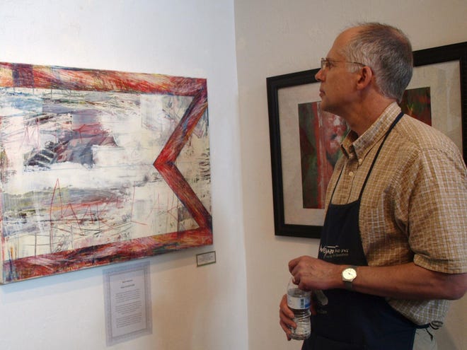 Contest judge Eric Wiegardt peruses paintings in the abstract section of the 10th annual National Juried Spring Exhibition at the Emerald Art Center in Springfield. Weigardt, a Washington watercolor painter, had to whittle 300 submissions down to the 66 that made it into the show. (Randi Bjornstad/The Register-Guard)