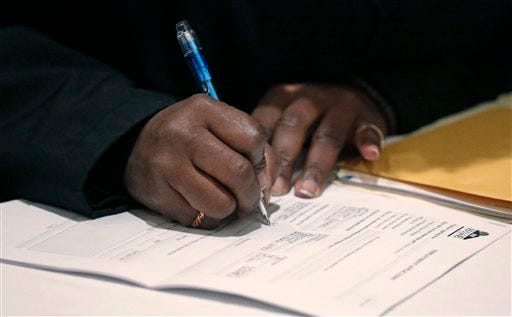 A job seeker fills out an application during a National Career Fairs job fair Wednesday, April 22, 2015, in Chicago. Weekly applications for jobless aid ticked up 1,000 to a seasonally adjusted 295,000, the Labor Department said Thursday, April 23, 2015. The four-week average, a less volatile measure, increased to 284,500. Still, that is just 2,000 higher than three weeks ago when the average was at a nearly 15-year low.(AP Photo/M. Spencer Green)