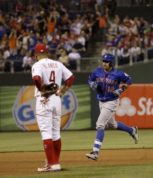 New York Mets' Juan Lagares, right, rounds the bases past Philadelphia Phillies third baseman Andres Blanco after Lagares hit a two-run home run off starting pitcher Aaron Harang during the seventh inning of a baseball game, Saturday, May 9, 2015, in Philadelphia. New York won 3-2. (AP Photo/Matt Slocum)