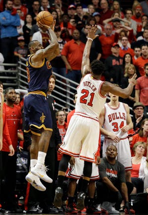 Cleveland Cavaliers' LeBron James, left, shoots the game-winning shot against Chicago Bulls guard Jimmy Butler during the second half of Game 4 in a second-round NBA basketball playoff series in Chicago on Sunday, May 10, 2015. The Cavaliers won 86-84. (AP Photo/Nam Y. Huh)