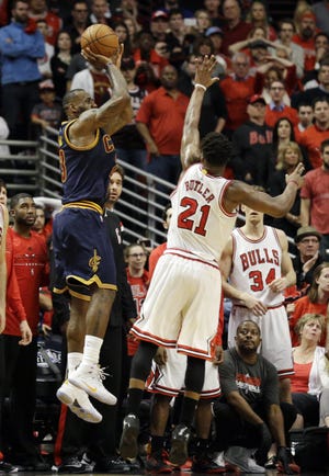 LeBron James, left, shoots the winning shot over guard Jimmy Butler to boost the Cavaliers past the Bulls. THE ASSOCIATED PRESS