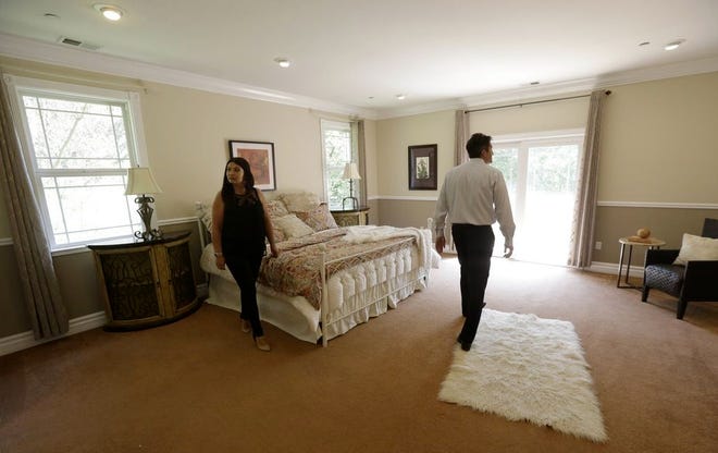 REALTOR STEPHAN MARSHALL,  right, walks with potential buyer Sasha Martinez at a home for sale in Pacifica, Calif. Homebuyers are expected to have a difficult time as the spring buying season starts.