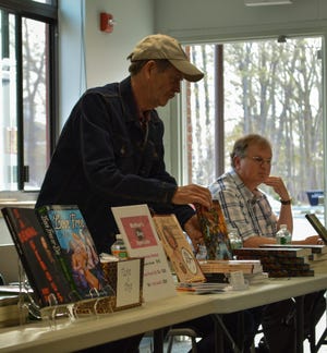 Author K.M. Doherty sets up a copy of his novel “Thomas Holland and the Prophecy of Elfhaven” at Stratham's Local Author's Night. Photo by Brian Ward/Seacoastonline.com