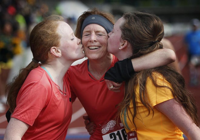 McKay Sohlberg (center) is given a kiss by her daughters, Ericka Sohlberg (left) and Tatum Sohlberg, after she completed the 13.1-mile half-marathon at the Eugene Marathon in Eugene on Sunday. The event coincided this year with Mother’s Day. (Andy Nelson/The Register-Guard)