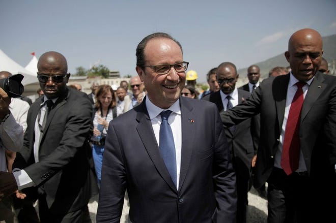 French President Francois Holland, center, and Haiti's President Michel Martelly, right, stand at the new facilities of the University Hospital in Port-au-Prince, Tuesday, May 12, 2015.