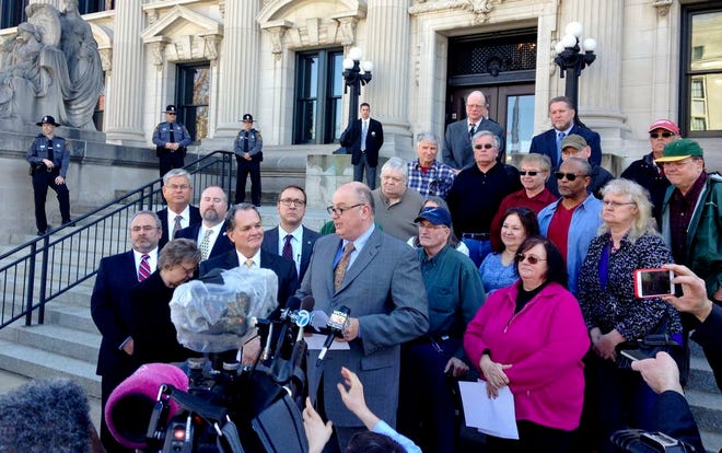 Illinois AFL-CIO President Michael Carrigan is joined by state workers and retirees outside the Illinois Supreme Court in Springfield, Ill., Wednesday, March 11, 2015, as he addresses the media following oral arguments in a lawsuit over a state pension overhaul.