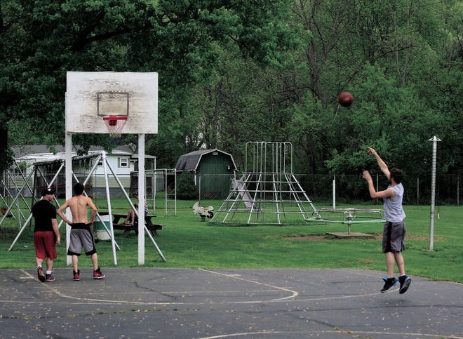 Basketball players shoot around on the court at Thornwood Park in Dennison. The Thornwood Park Restoration Group is raising money to replace the basketball court and playground equipment at the park.