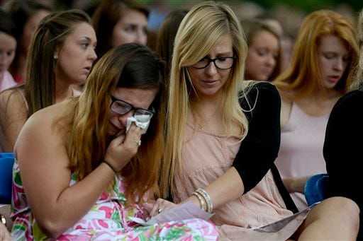 Members of Alpha Omicron Pi console each other during a candlelight vigil and memorial service for five nursing students who were killed in a multi-vehicle accident, Thursday, April 23, 2015, at Georgia Southern's Statesboro campus in Statesboro, Ga. The deadly, chain-reaction crash early Wednesday on Interstate 16 involved six vehicles. (Ian Maule/Savannah Morning News via AP)