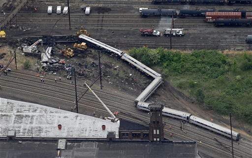 Emergency personnel work at the scene of a deadly train derailment, Wednesday, May 13, 2015, in Philadelphia. The Amtrak train, headed to New York City, derailed and crashed in Philadelphia on Tuesday night, killing at least six people and injuring dozens of others. (AP Photo/Patrick Semansky)