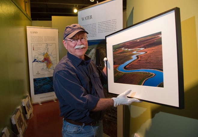 Photographer Rich Turner holds up one of his photos that he will have in a one-man show about the Delta at the San Joaquin County Historical Society Museum at Micke Grove in Lodi. CLIFFORD OTO/THE RECORD