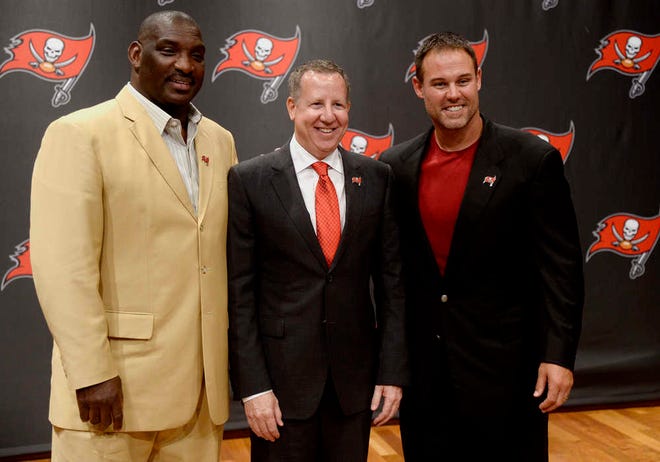 Tampa Bay Buccaneers co-chairman Bryan Glazer poses for pictures with former quarterback Doug Williams, left, and former fullback Mike Alstott following a news conference Wednesday that announced the two would be inducted into the Tampa Bay Buccaneers Ring of Honor. (Jason Behnken/The Tampa Tribune via AP)