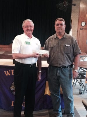 Lion President Carl Whaley, on right, presents a check for $3,700 to Vice District Governor Max Bumgardner.