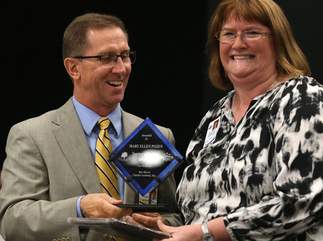 Dr. Tim Kitts presents North Bay Haven's Mary Pozen with the Teacher of the Year Award. Bay Haven Charter Academy Inc. held its first Teacher and Support Employee of the Year ceremony.