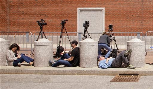 Members of the media wait outside the John Joseph Moakley United States Courthouse during the closing statements phase of the Dzhokhar Tsarnaev federal death penalty trial on Wednesday, May 13, 2015, in Boston. Tsarnaev is charged with conspiring with his brother to place two bombs near the Boston Marathon finish line that killed three and injured 260 spectators in April 2013. (AP Photo/Stephan Savoia)