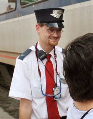 In this Aug. 21, 2007, file photo, Amtrak assistant conductor Brandon Bostian stands by as passengers board a train at the Amtrak station in St. Louis. Federal investigators have determined that an Amtrak train that crashed in Philadelphia on Tuesday, killing at least seven people, was careening through the city at 106 mph before it ran off the rails along a sharp curve. The attorney for Bostian, the engineer at the controls of the train, said Thursday, his client has no recollection of the accident.