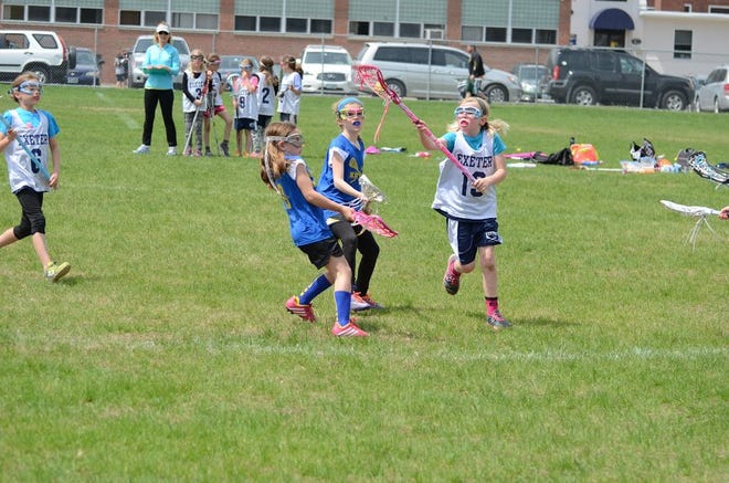 Exeter's Hannah Outhouse, right, takes the ball away from a Kittery player and scores a goal in last Saturday's youth lacrosse game. Courtesy photo