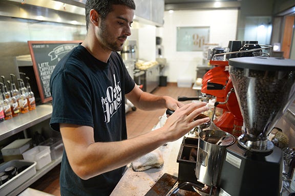 Students say they gravitate to the Oak House in Elon because it's locally owned. Here assistant manager Matthew Johnston prepares an iced caramel macchiato this week.