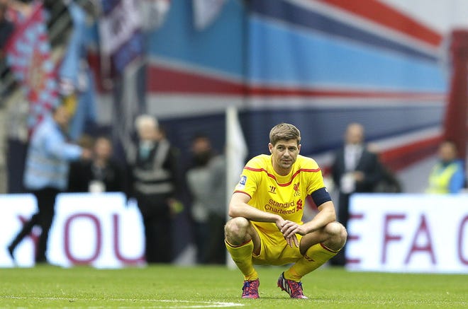 Liverpool's captain Steven Gerrard looks on as Aston Villa fans celebrate after the end f the English FA Cup semifinal soccer match between Liverpool and Aston Villa at Wembley Stadium in London, Sunday, April 19, 2015. Aston Villa won the match 2-1 and will play Arsenal in the final. (AP Photo/Tim Ireland)