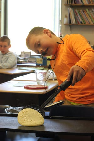 Gavin Hartung, a third-grader at Hudson’s Lincoln Elementary School, shows his classmates Thursday how to make “the perfect pancake” Thursday as part of the school’s “The Leader in Me” grant-funded program. The program gives students a chance to demonstrate talents and leadership skills.