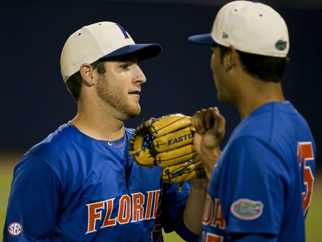 Florida's Aaron Rhodes gets a fist bump from teammate Danny Young, right, after a successful inning against Auburn.