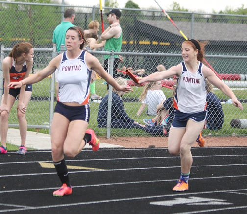 Pontiac’s Kelly Pagel, left, takes the baton from Kaci Rhodes during the 4x200 relay at the Corn Belt Conference meet last weekend. Pagel and Rhodes were joined by Meghan Heller and Sarah Christopher in winning the 4x200, as well as the 4x100, relay Friday at the Class 2A Plano Sectional meet. Rhodes also placed second in the 200-meter dash to advance to state in three events.