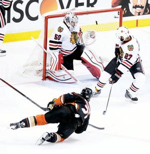 Anaheim Ducks right wing Kyle Palmieri, bottom, scores past Chicago Blackhawks goalie Corey Crawford as Johnny Oduya looks on during the second period of Game 1 of the Western Conference final during the NHL hockey Stanley Cup playoffs in Anaheim, Calif., Sunday.