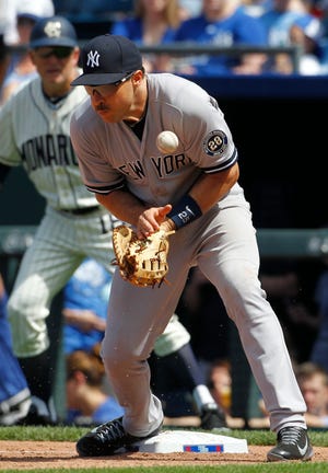 New York first baseman Mark Teixeira is unable to catch a throw from second baseman Stephen Drew Sunday on a hit by Kansas City's Omar Infante during a game at Kauffman Stadium in Kansas City, Mo. The Yankees lost, 6-0. THE ASSOCIATED PRESS