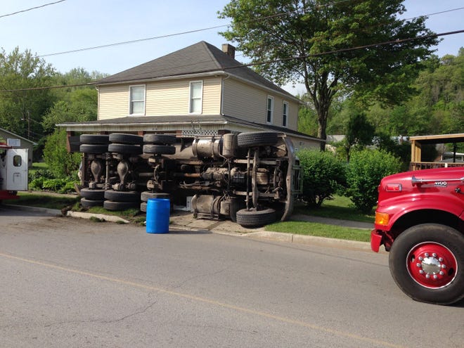 An overturned truck rests in the front yard of a home on Main Street in Wampum after an accident Monday morning.