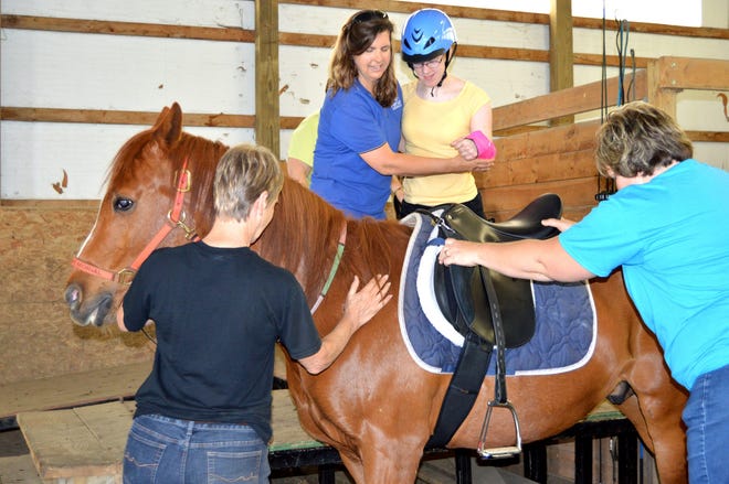 Renew Therapeutic Riding Center Executive Director Melissa Conner helps Caitlin from the Ottawa Area Center mount "Max" Monday, May, 18, 2015 during a riding session for the school. The center needs volunteers to help with rides, because it takes a three volunteer to one rider ratio. Annette Manwell/Sentinel staff