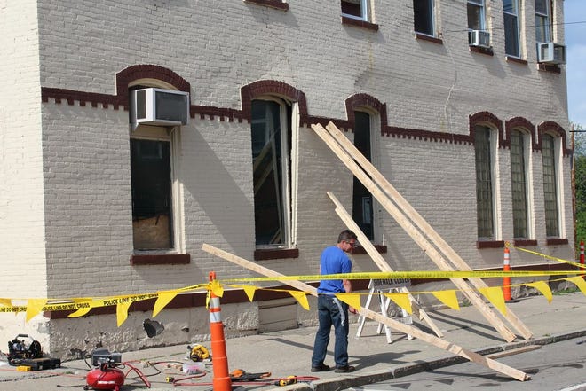 Knapp House owner Bill Foster fixes bracing to keep the brick façade of the building from collapsing.