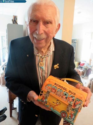 Al Konetzni holds his famed Disney school bus lunch box. Nine million of them were sold.