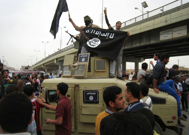 In this March 20, 2014 file photo, Al-Qaida fighters wave al-Qaida flags as they patrol in a commandeered Iraqi military vehicle in Fallujah, Iraq.