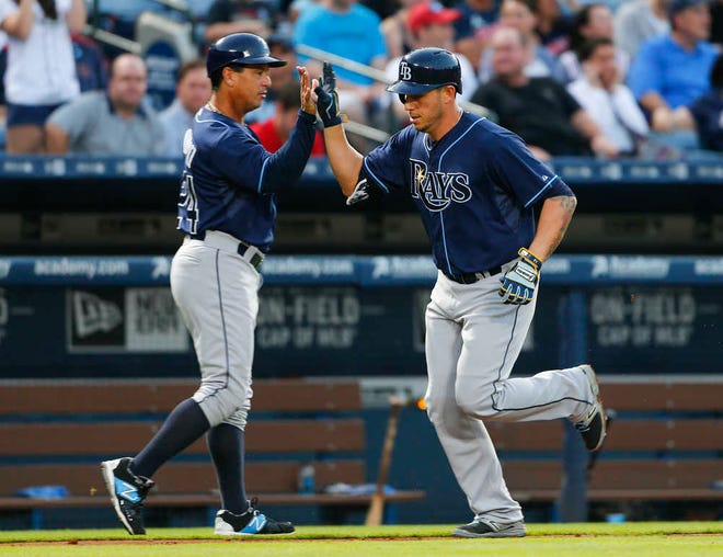 Tampa Bay Rays shortstop Asdrubal Cabrera (13) celebrates with third base coach Charlie Montoyo (24) as he rounds the bases after hitting a home run in the fourth inning of a baseball game against the Atlanta BravesTuesday, May 19, 2015, in Atlanta. Tampa Bay won 5-3. (AP Photo/ John Bazemore)