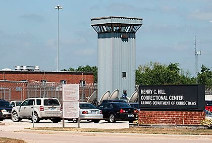 This July 25, 2011, photo shows the Hill Correctional Center in Galesburg. A scathing report released Tuesday, May 19, 2015, cited several "significant lapses" of medical care in Illinois prisons, including the case of a 48-year-old prisoner at Hill who pleaded for medical help after he began feeling chest pain and coughing up blood. But the report said it took six months for doctors to locate a softball-size cancerous tumor clinging to his neck area and lung. (AP Photo/The Register-Mail, Steve Davis)