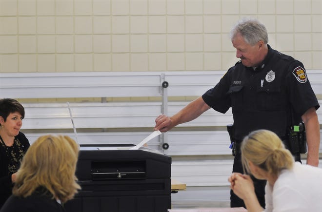 In Oxford voting at the A.M. Chaffee Elementary School, all eyes were on Police Officer John Puniskis as he voted on Tuesday. T&G Staff/Christine Peterson