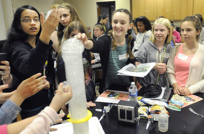 Holicong Middle School student Olivia Newman (center) gets a close-up look at a soapy chemical reaction as she joins other girls taking part in the STEM program held at DelVal University on Thursday, May 21, 2015.