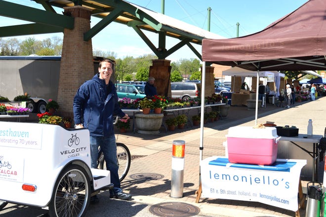 Matt Wright, owner of PetalCab, prepares to take off from the Holland Farmers Market after making a coffee delivery for Lemonjellos Wednesday, May 20. Interest in the pedicab is slowly picking up after a whirlwind week of Tulip Time. Annette Manwell/Sentinel staff