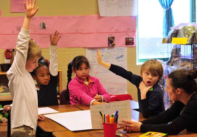 A group of first graders raise their hands as Katherine Brown, right, asks a question in a first-grade classroom at J.J. Harris Elementary School on Thursday, Feb. 19, 2015.  (Richard Hamm/Staff) OnlineAthens / Athens Banner-Herald