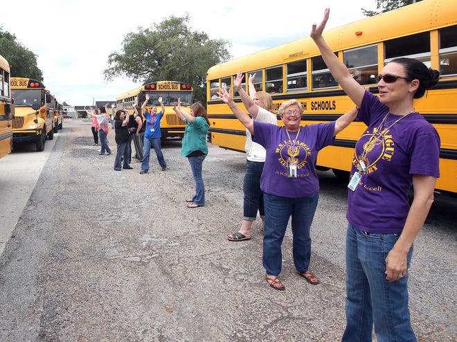 Teachers at W.S. Lafargue Elementary School wave goodbye to students Friday afternoon, the last day of classes in Lafourche Parish.