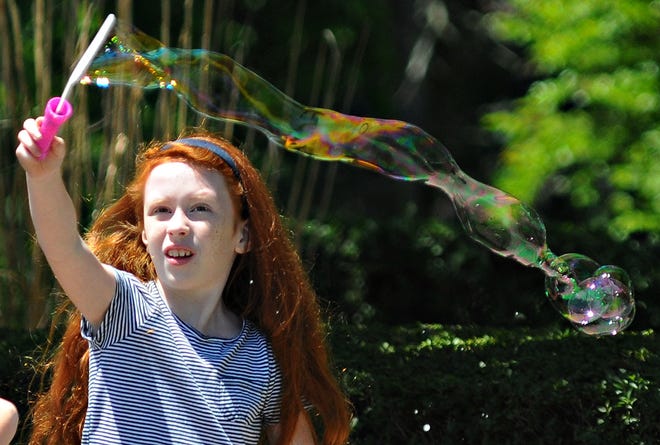 Hannah Morgan, 9, of Tullytown, creates a large bubble Saturday, May 23, 2015, before Tullytown's annual Memorial Day parade.