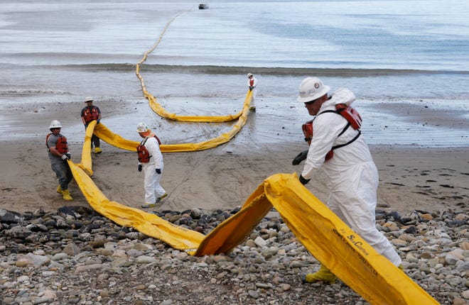 Workers prepare an oil containment boom at Refugio State Beach, north of Goleta, Calif., Thursday, May 21, 2015. More than 7,700 gallons of oil has been raked, skimmed and vacuumed from a spill that stretched across about 9 miles of California coast, just a fraction of the sticky, stinking goo that escaped from a broken pipeline, officials said.
