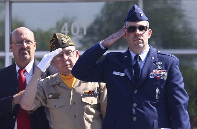 From left Wayne McCulloch Secretary/Treasurer of Warminster Township, VFW Post 6493 Chaplain Mike Casey and Capt. Sean Pearson of the Pennsylvania Air National guard salute the flag before the Warminster Memorial Day parade, Monday, May 25, 2015.