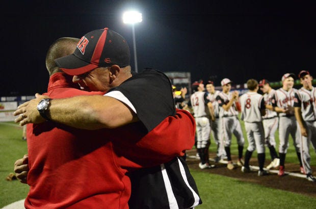 West Allegheny head coach Bryan Cornell gets a hug from football coach Bob Palko after the Indians defeated Blackhawk for the WPIAL Class AAA baseball championship at Consol Energy Park on May 29, 2014.